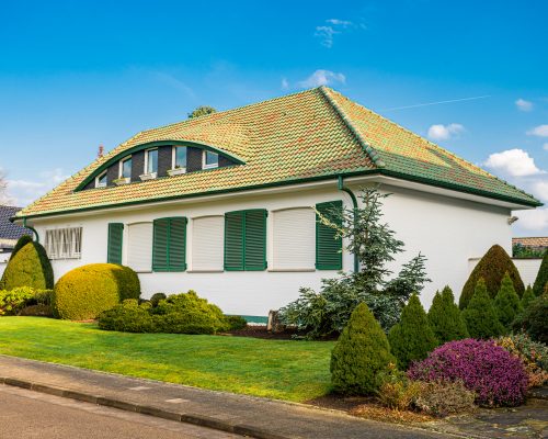 Facade of luxury detached house with beautiful garden